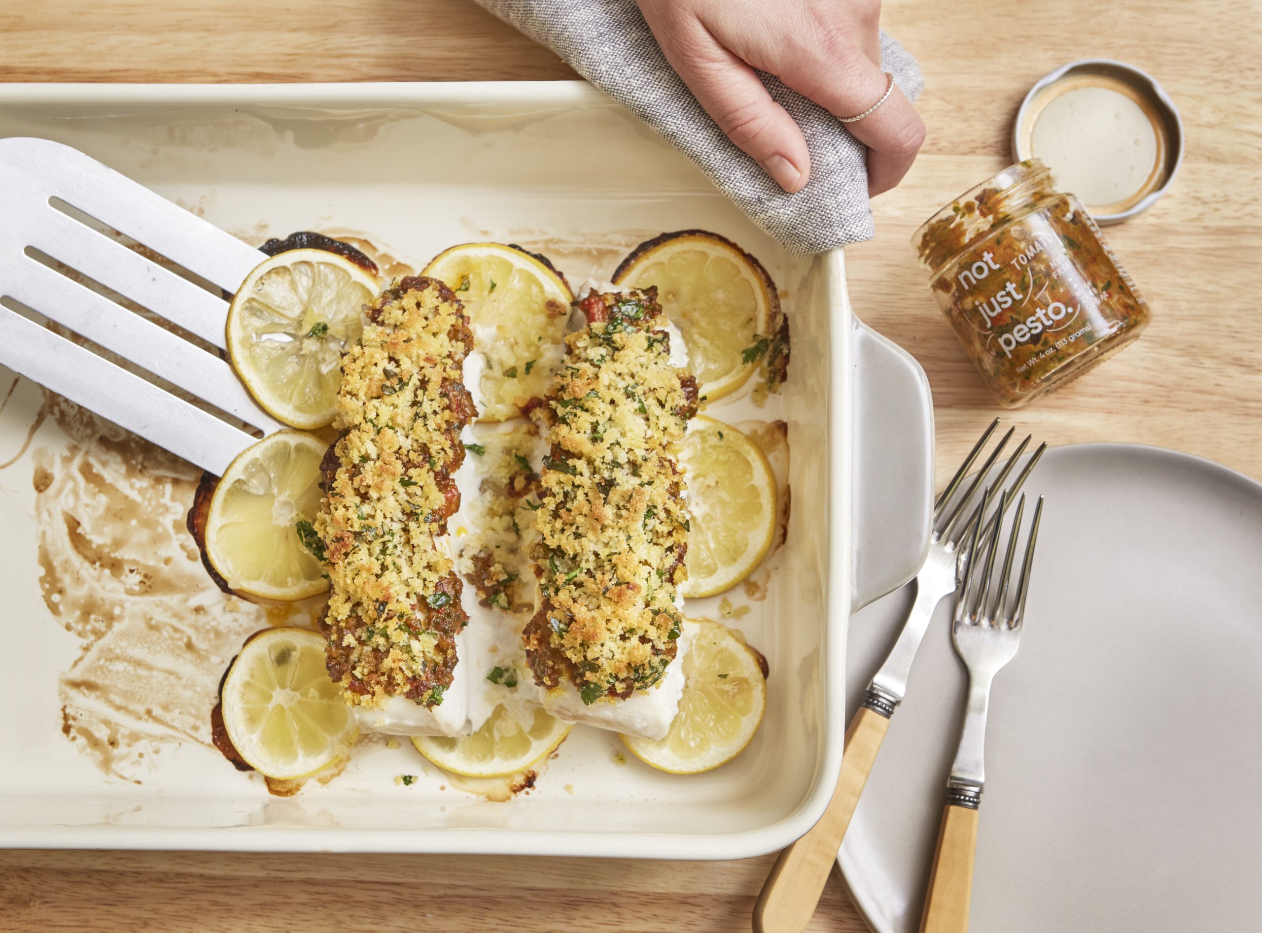 baked fish with lemony breadbrumbs and not just pesto being taken out of pan