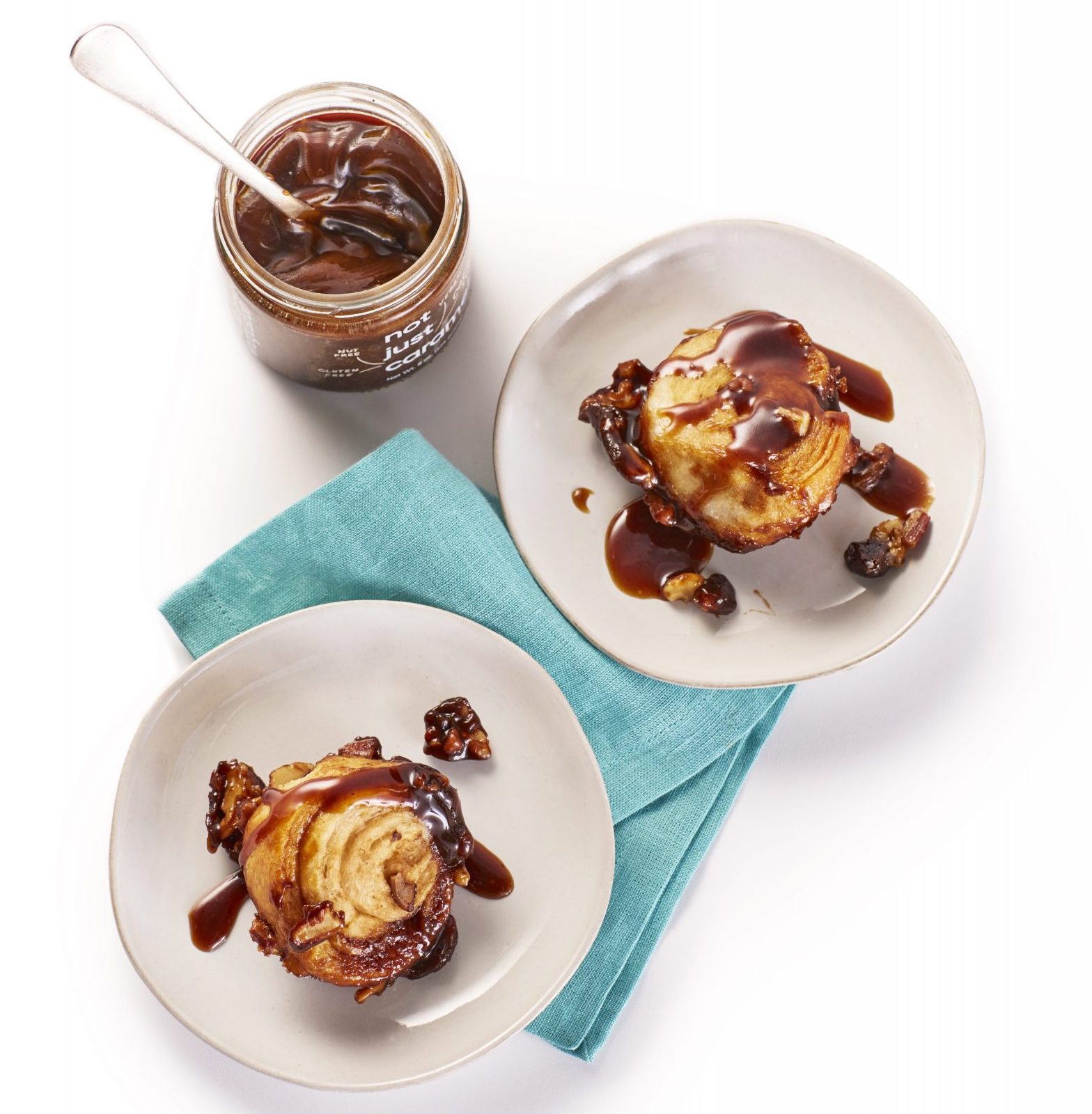 caramel pull-apart bread on a blue napkin with a jar of not just caramel