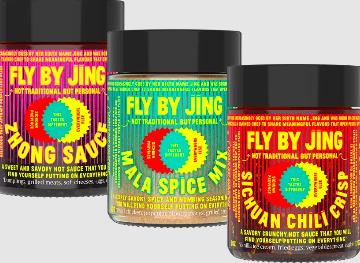 a line of three jars of fly by jing products. chili crisp in front, mala spice in middle, zhong sauce in the back