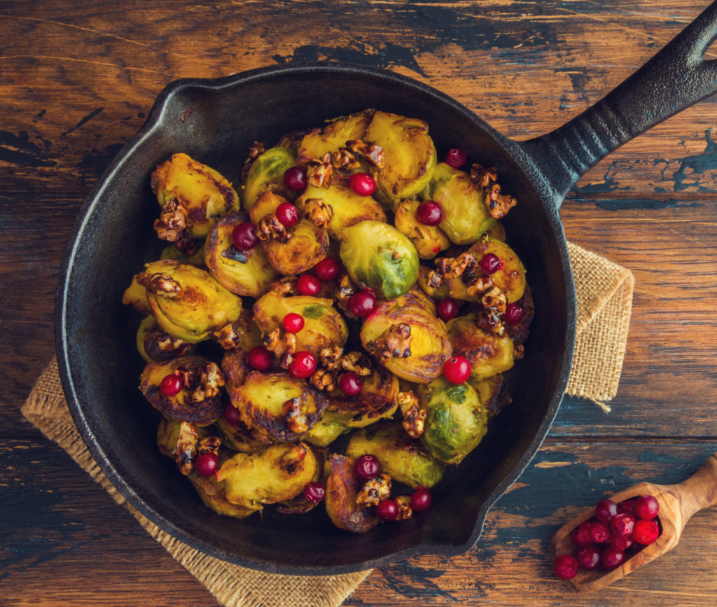 Roasted brussel sprouts in cast iron skillet with pomegranates and lemon miso dressing