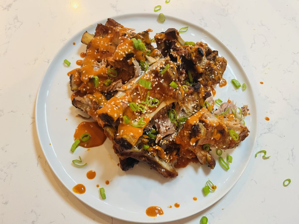 Korean charred ribs on plate with scallions and sesame seeds